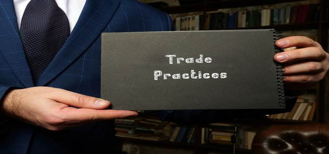 man holding sign that reads "trade practices"